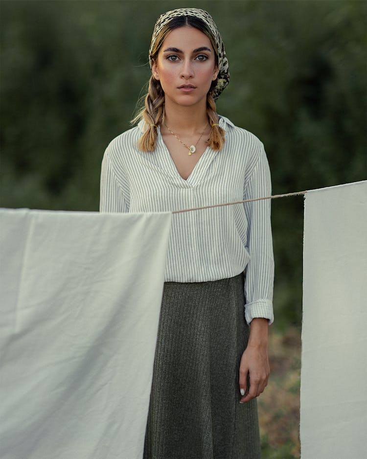 Woman In Headscarf Standing Behind A Clothesline 