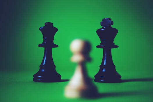 Close-up of chess pieces on a green board, highlighting strategy and focus.
