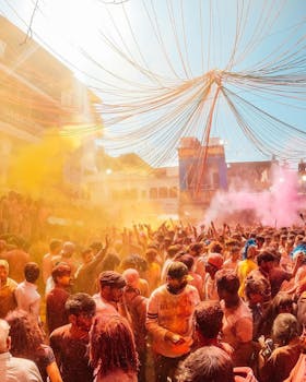 Vibrant Holi festival with a crowd covered in colorful powders, celebrating outdoors.