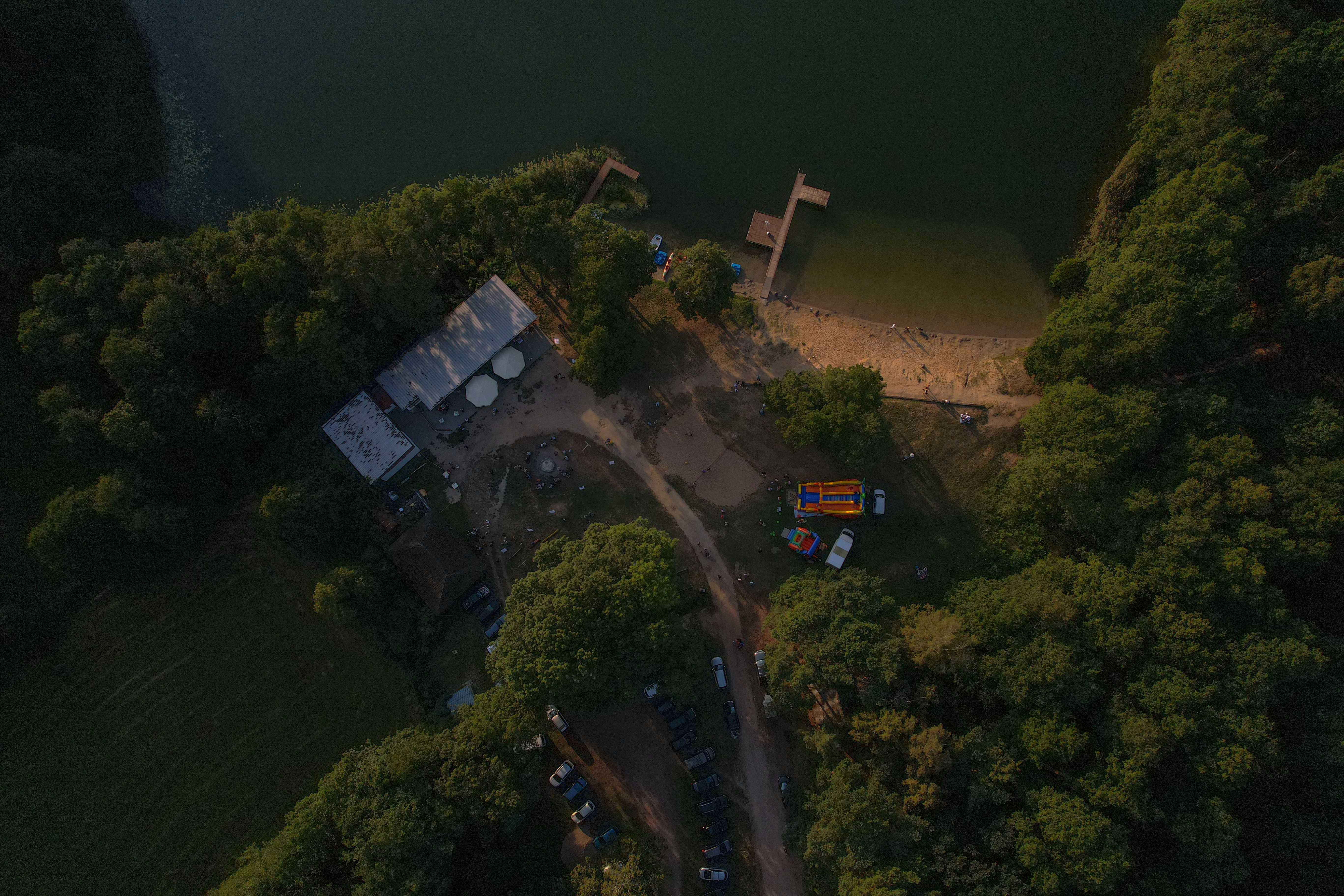 Aerial view of a lakeshore with surrounding forest and a beach area
