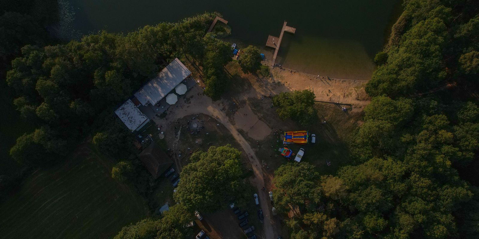 Aerial view of a lakeshore with surrounding forest and a beach area
