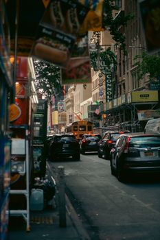 Traffic congestion on a bustling street in New York City with cars, taxis, and signages.
