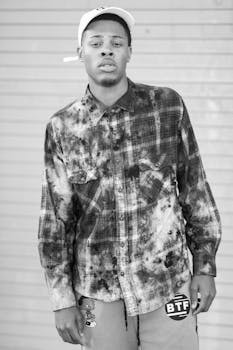 Black and white portrait of a young man in casual attire with a neutral expression.