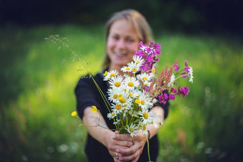 Photography of Woman Holding Flowers