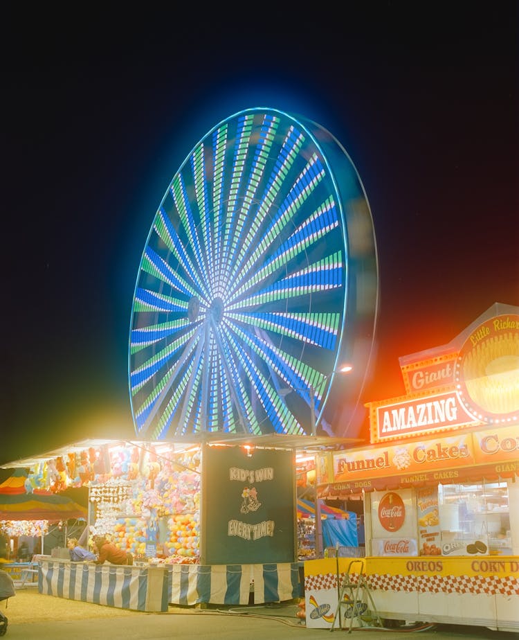 A Ferris Wheel With Lights At Night