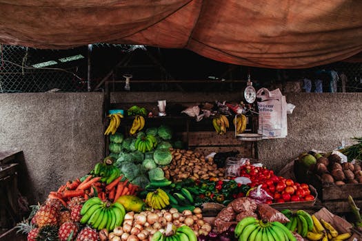 Photo by Shane Kell Colorful array of fruits and vegetables at a market stall with rustic ambiance.