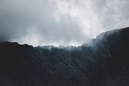 一个喜怒无常的山脊，部分笼罩在云雾之中，营造出戏剧性的景观