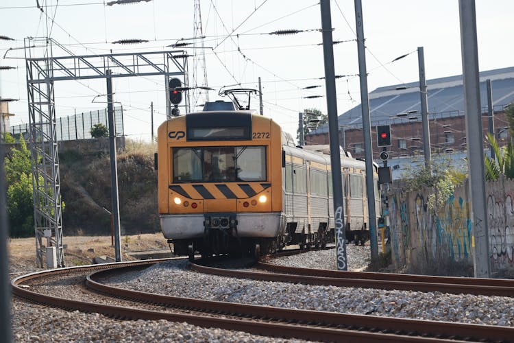 Yellow Passenger Train On Railroad 