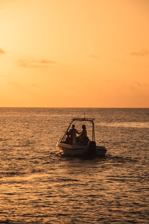 People on a Boat on Sea During Sunset