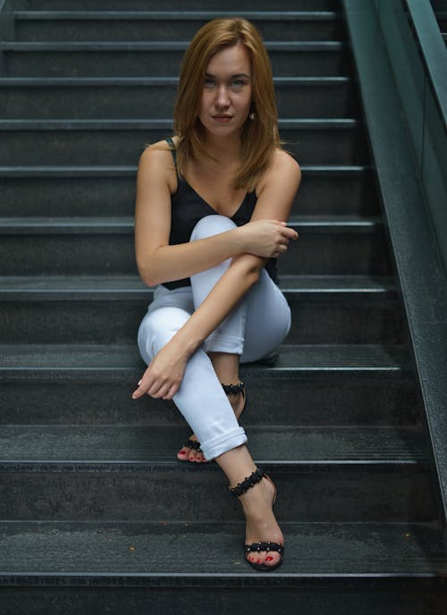 Woman in White Jeans Sitting on Stairs