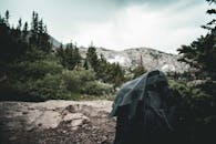 背包休息时，周围是郁郁葱葱的森林和岩石嶙峋的山景