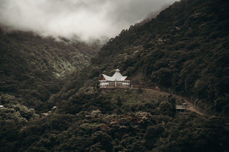 Building In Forest In Mountains Under Clouds