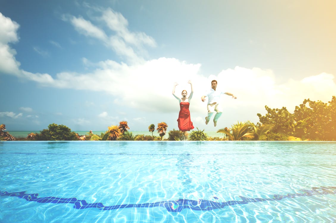 Free Man and Woman Jump on Water Stock Photo
