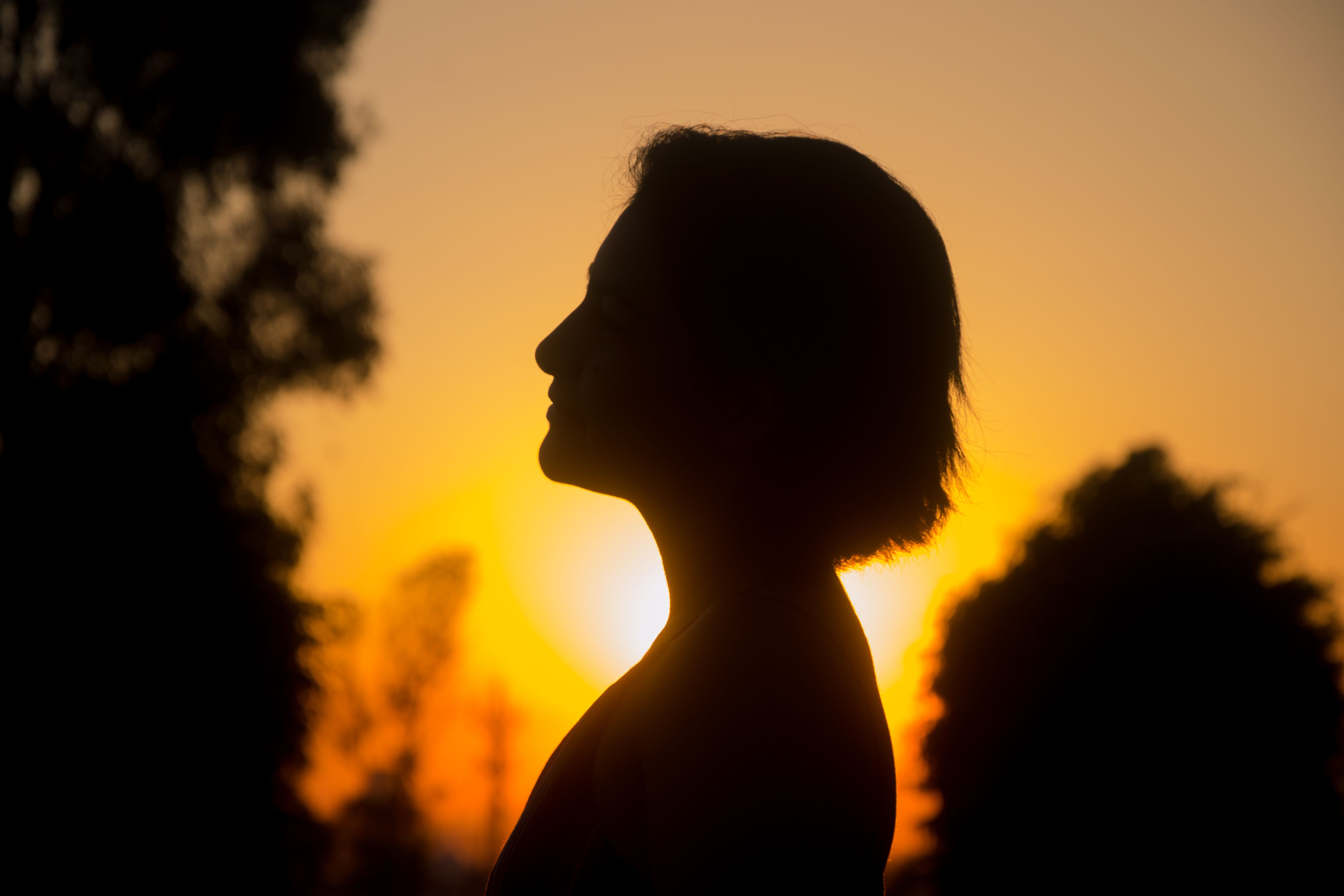Silhouette of a woman against a vibrant sunset in Puebla, Mexico, capturing a serene and tranquil moment.