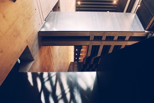 Free Contemporary interior featuring abstract shadows on concrete and metal surfaces, showcasing minimalist design. Stock Photo