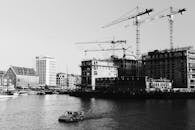 黑白照片里是一个海滨建筑工地，上面有起重机和船只