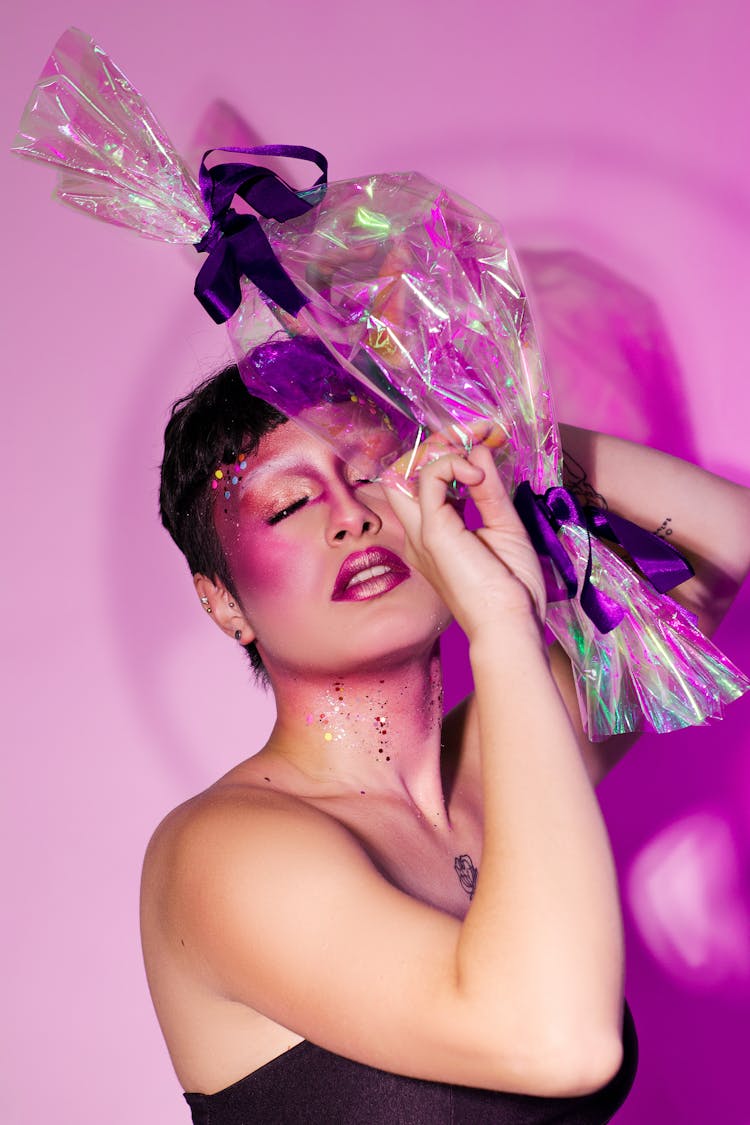 Woman In Creative Makeup Holding A Plastic Bag In A Shape Of A Candy 