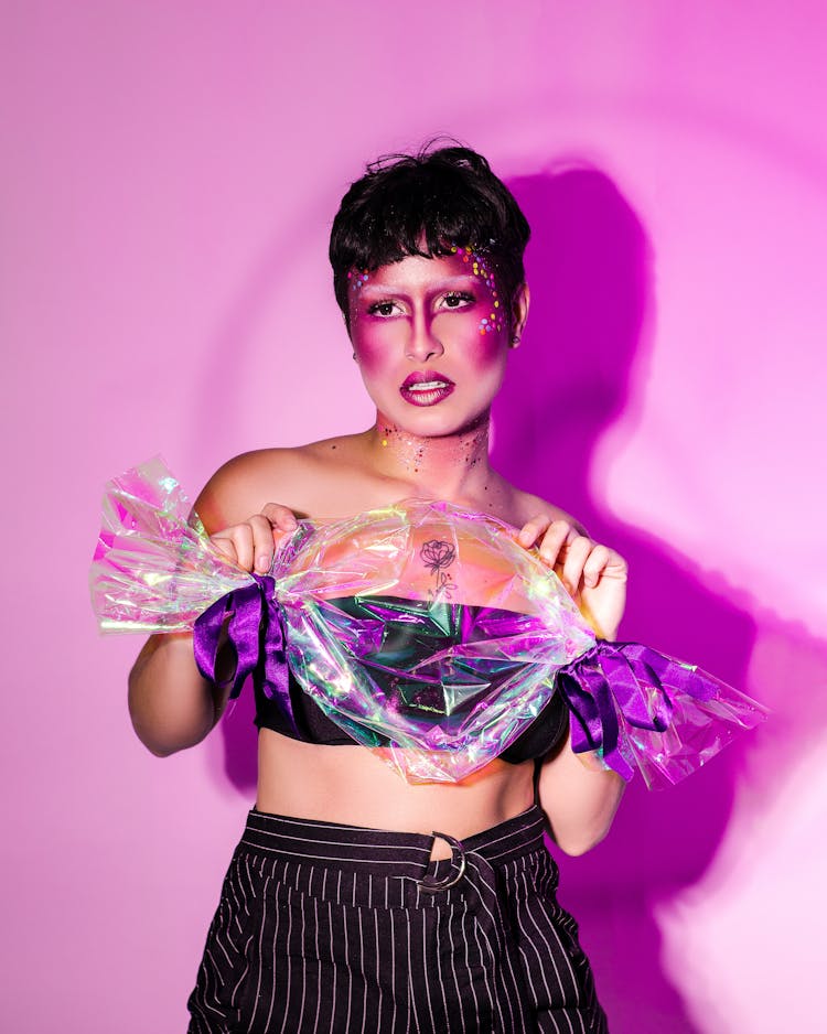 Woman In Creative Makeup Holding A Plastic Bag In A Shape Of A Candy 