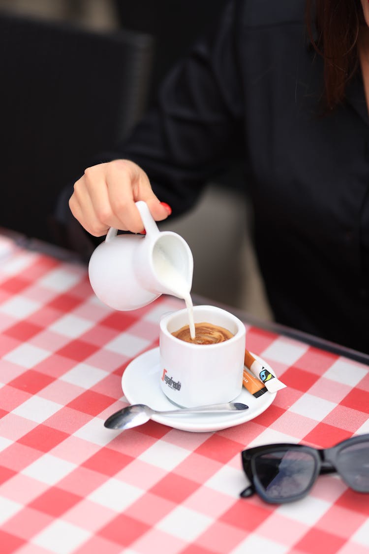 Woman Pouring Milk To Her Coffee