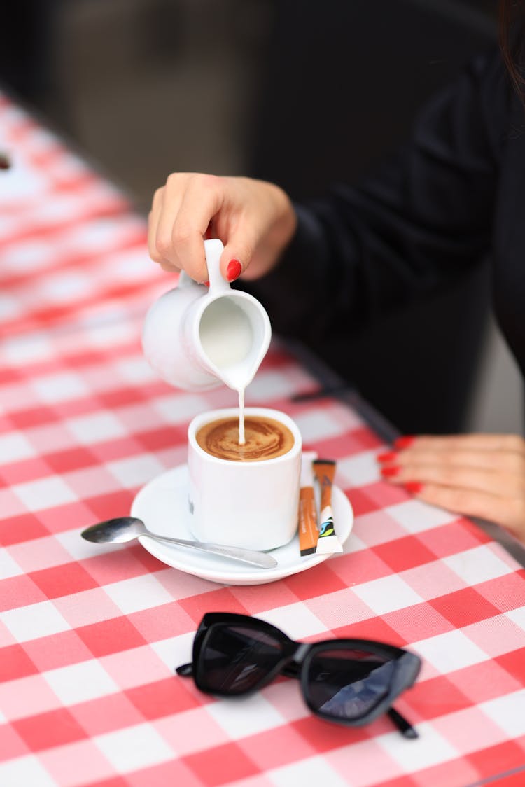 Woman Pouring Milk On Coffee