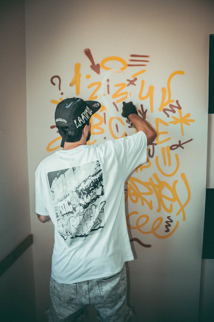 Man Spray Painting A Wall