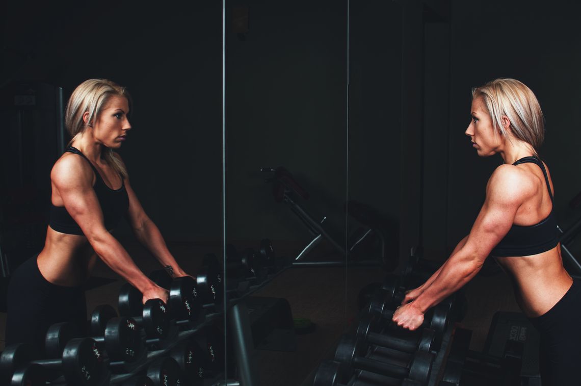 Real athlete training with dumbbells in a gym environment