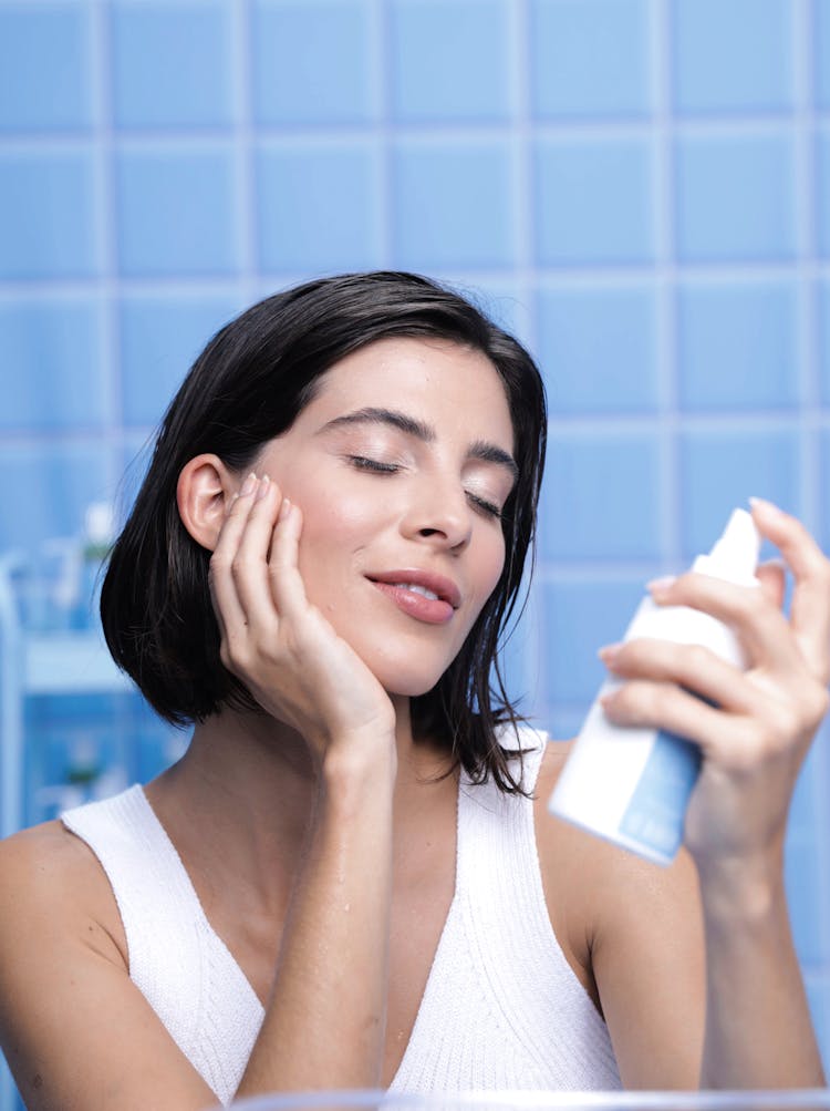 Brunette Woman Applying A Moisturizer On A Face Skin 