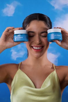 Cheerful woman with closed eyes holding skincare jars displaying glowing skin care concept.