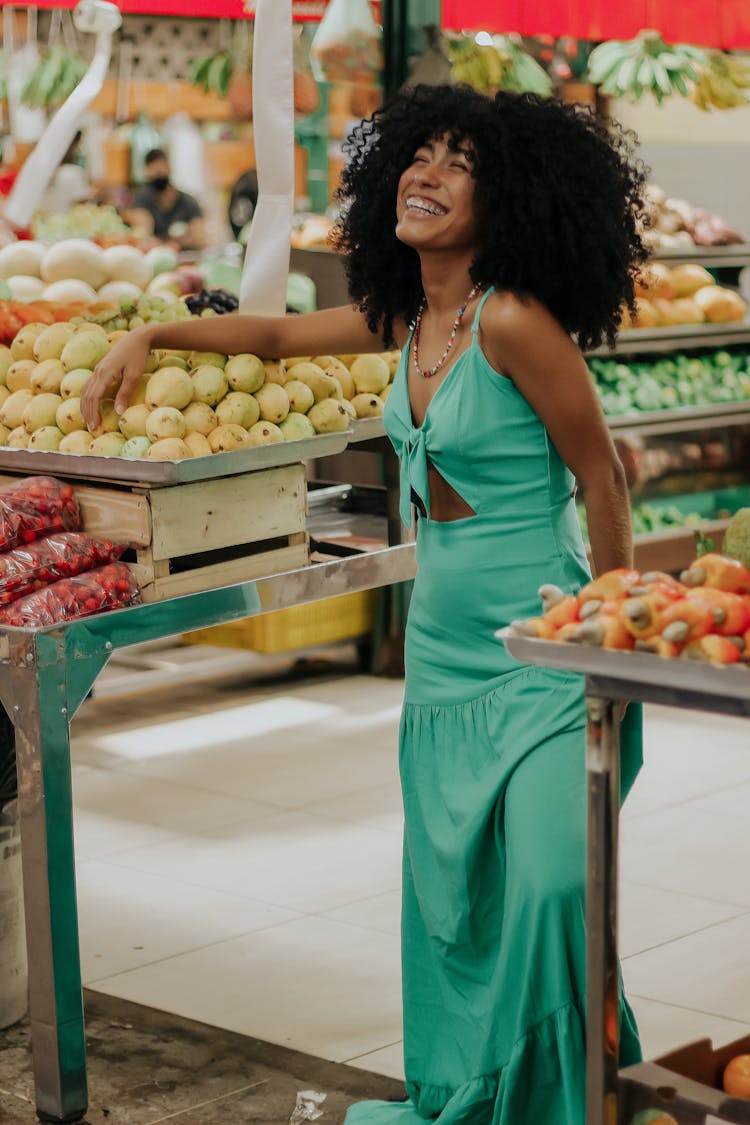 Laughing Brunette Woman Standing At A Fruit And Vegetable Stand 