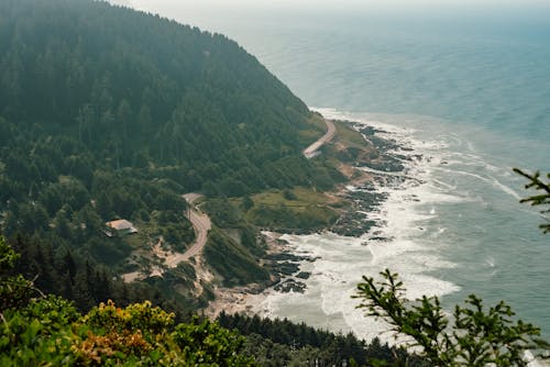 Aerial View of Green Mountain Near Body of Water