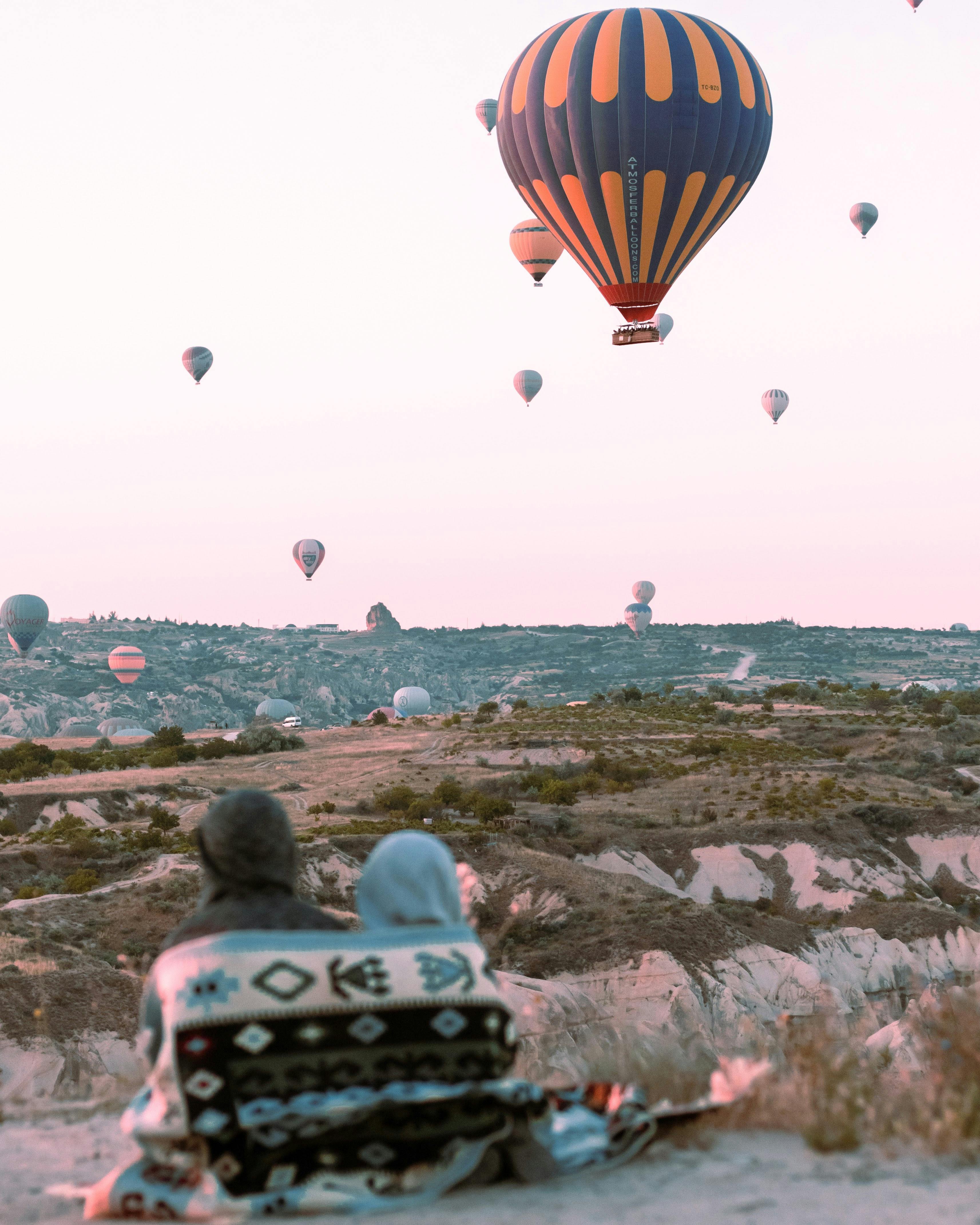 back view of a couple watching hot air balloons flying over cappadocia