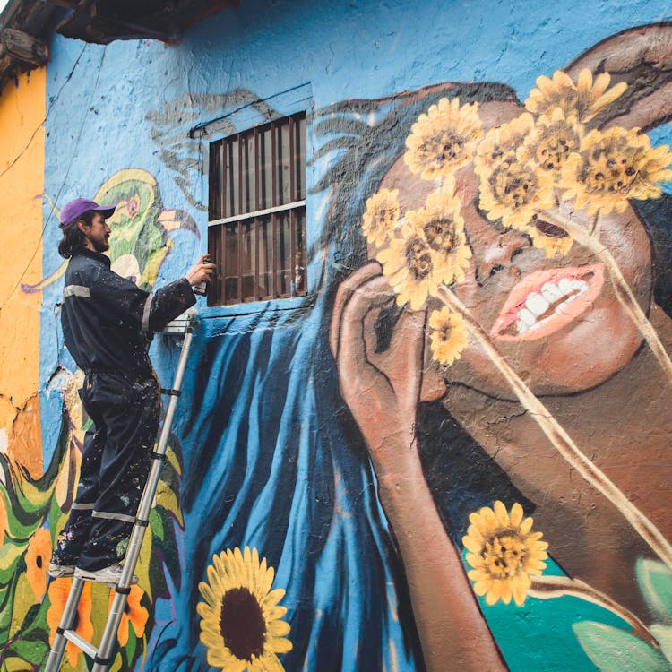 Man Doing A Mural On Wall