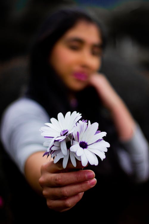 Close-Up Shot of a Woman Holding Purple Flowers
