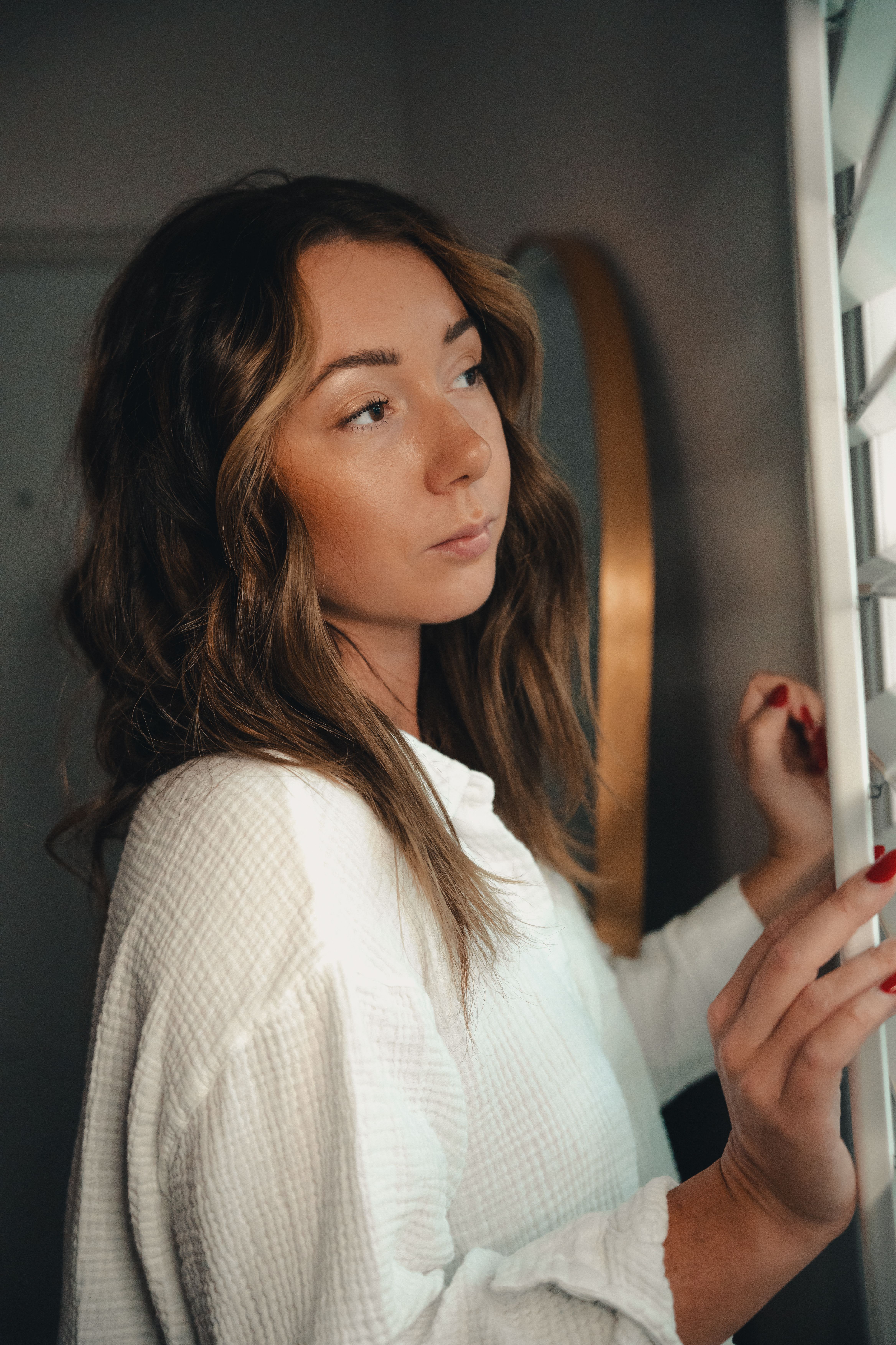 Woman in White Long Sleeve Shirt Looking at the Window · Free Stock Photo