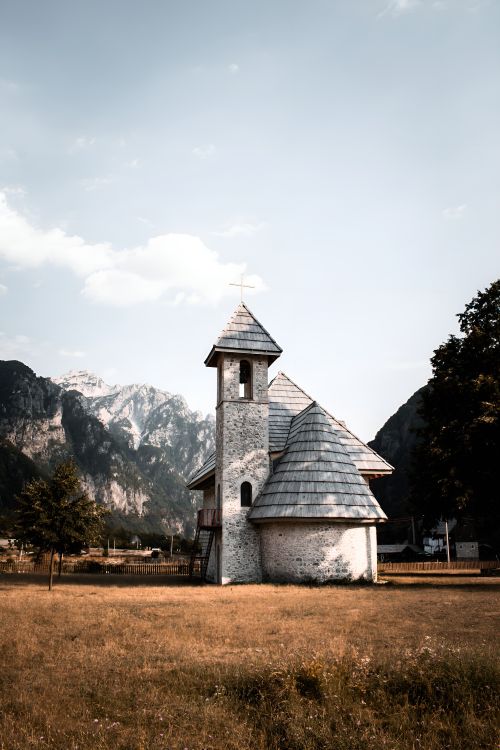 Free Explore the tranquil beauty of a traditional church set against Albania's stunning mountainous backdrop in Theth. Stock Photo