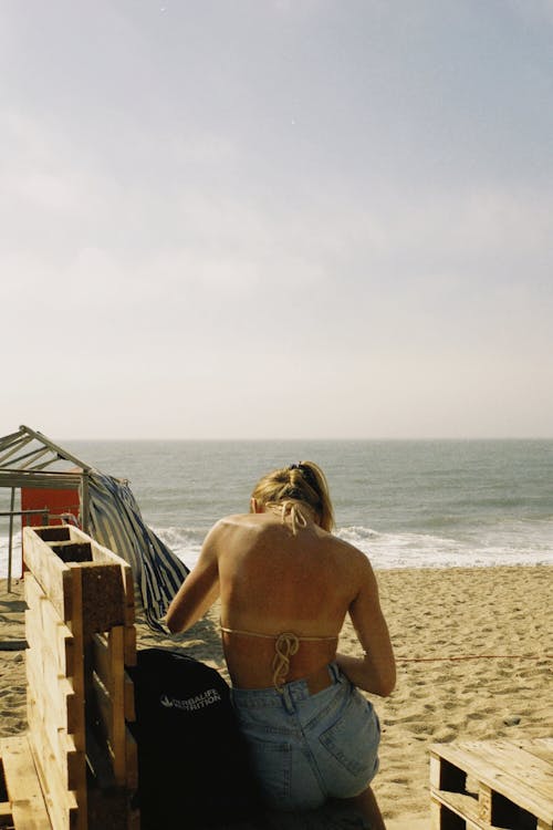 Woman in Bikini Top Sitting at the Beach