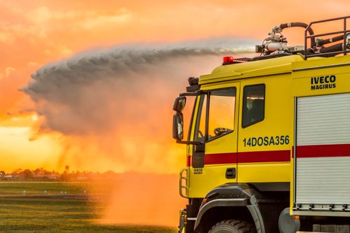 Free A fire truck sprays water during a dramatic sunset in João Pessoa, Brazil. Stock Photo