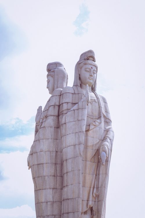 Free Two majestic Buddha statues stand tall under a bright sky. Stock Photo