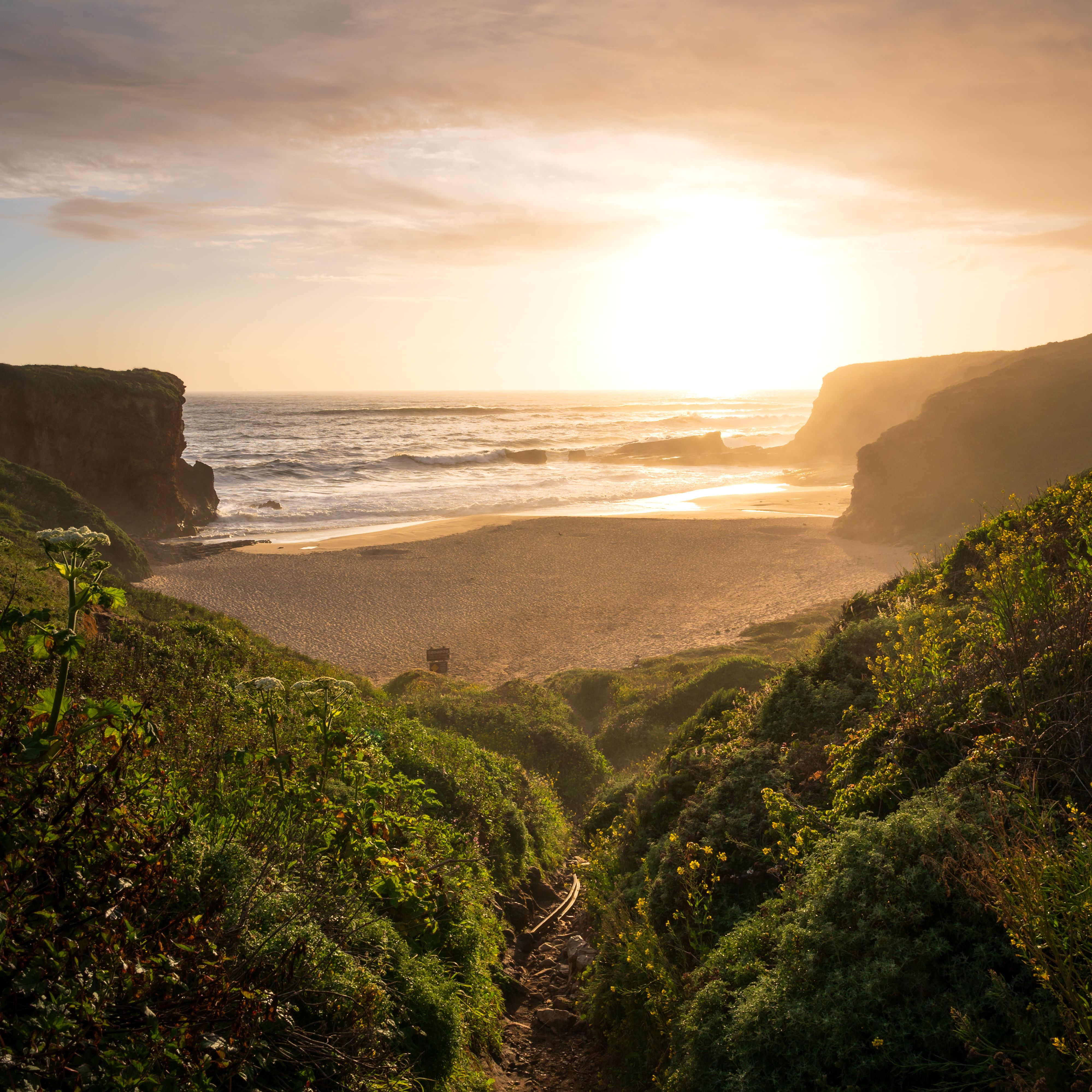 A cove at sunset seen from a grassy path, photo by Zetong Li on Pexels