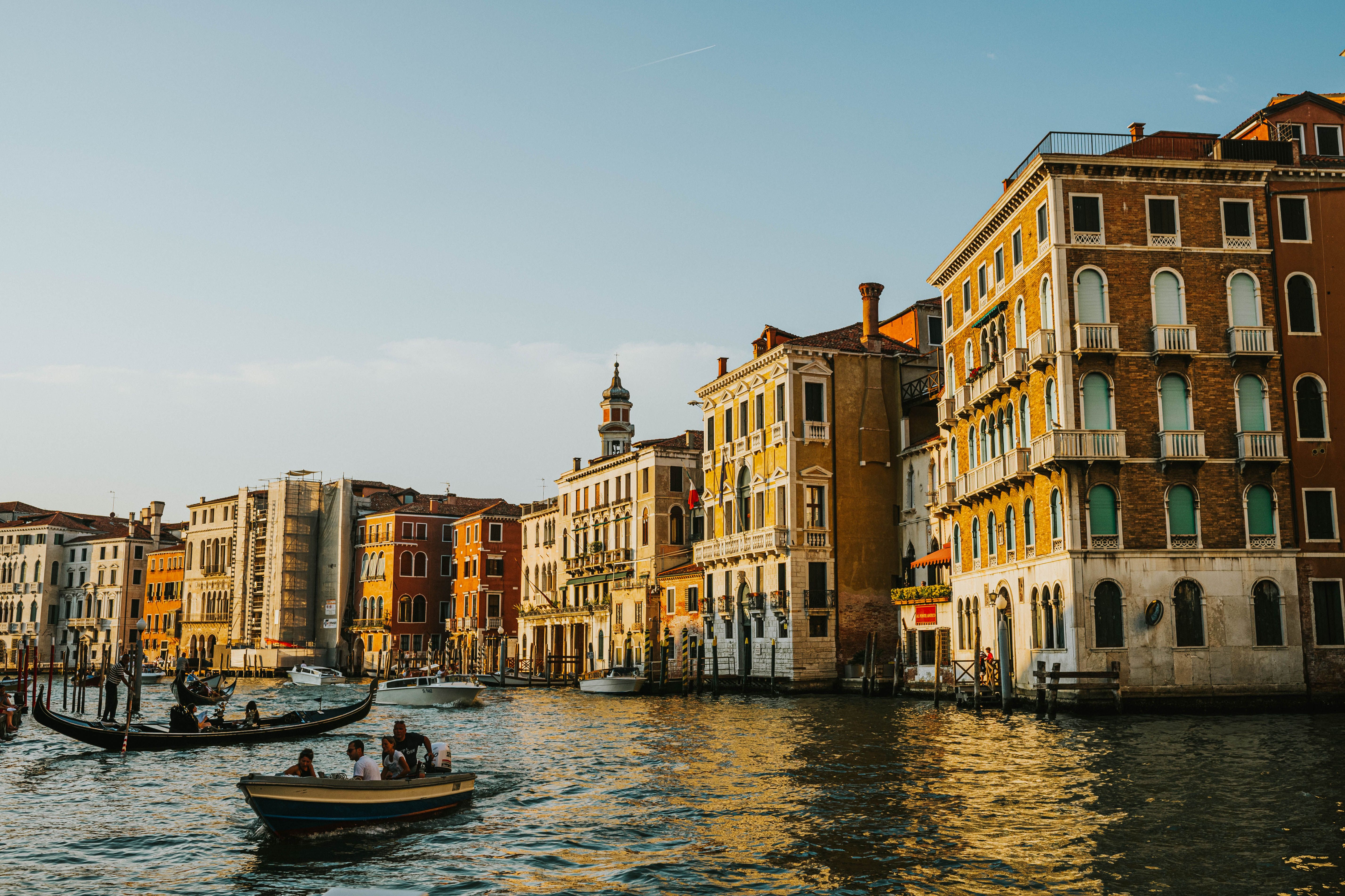 Stunning view of Venetian buildings along the Grand Canal with gondolas at sunset. Stunning view of Venetian buildings along the Grand Canal with gondolas at sunset.