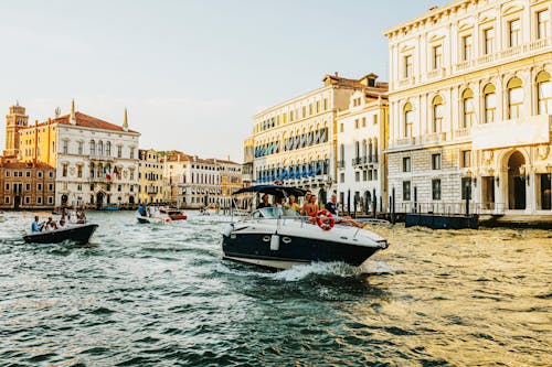 White and Black Boat Sailing Near Buildings