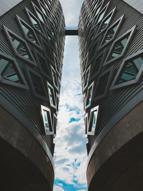 Low Angle Photography of Two Building Under White Clouds