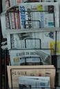 White and Blue Newspaper on White Shelf
