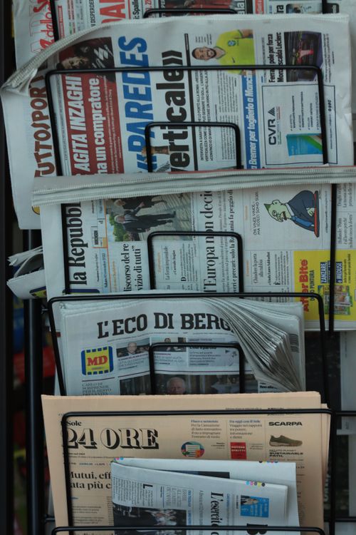 Free Stack of Italian newspapers on a street kiosk in Turin, Italy, highlighting daily news. Stock Photo