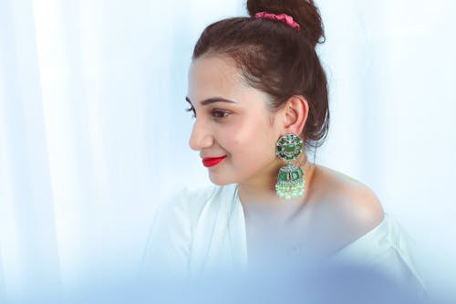 A Woman Wearing Green Earring Looking Afar