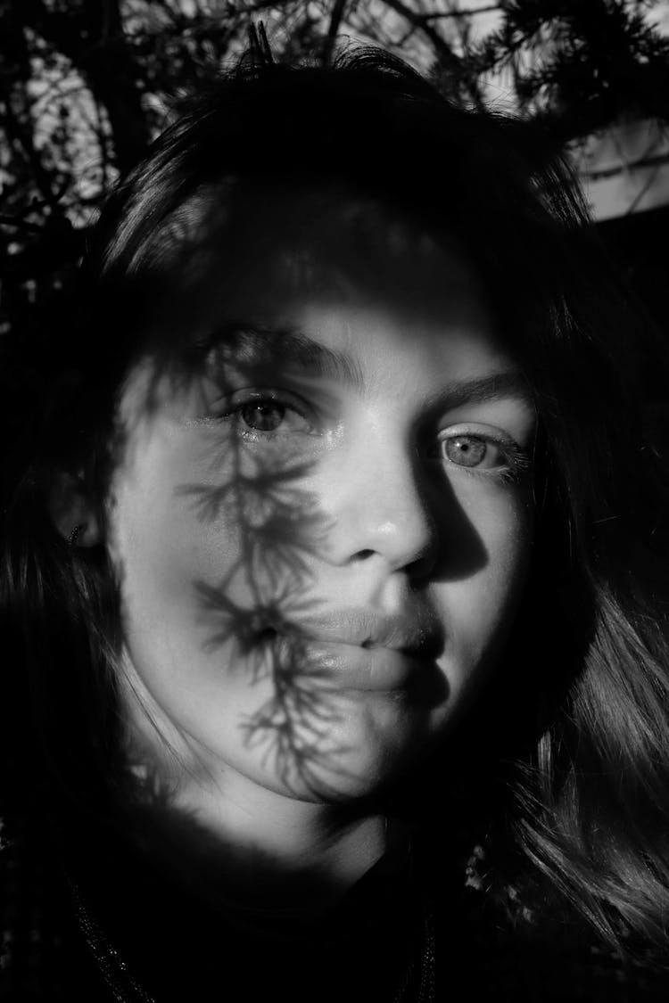 Grayscale Photo Of Woman With Leaves Shadow On Face