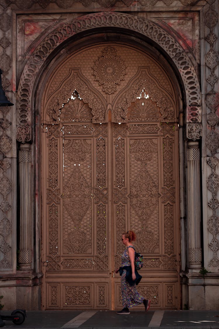 A Woman Walking Along A Building