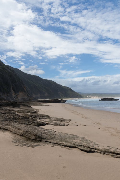 Sea Shore near Mountain under the Cloudy Sky