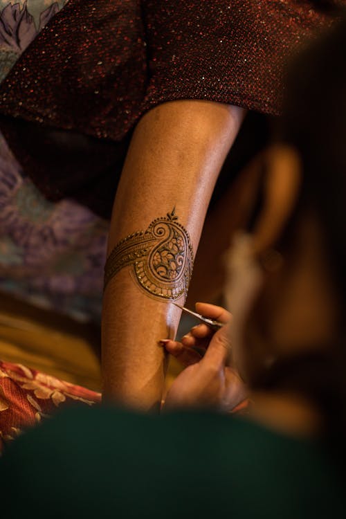 Free Person Applying Henna Tattoo on Person's Leg Stock Photo