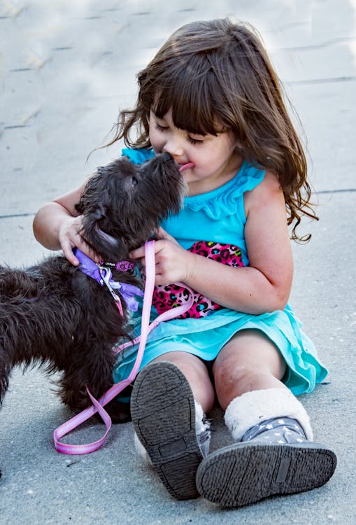 Chien noir à côté de petite fille